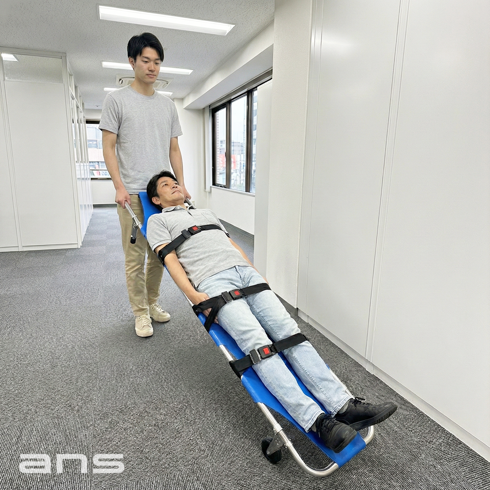 ANS 11 車輪付き軽量折りたたみ担架。片側に車輪が2個装備されているので、緊急の場合は１人で傷病者を運ぶことも可能。半分に折り畳めるので収納も簡単です。